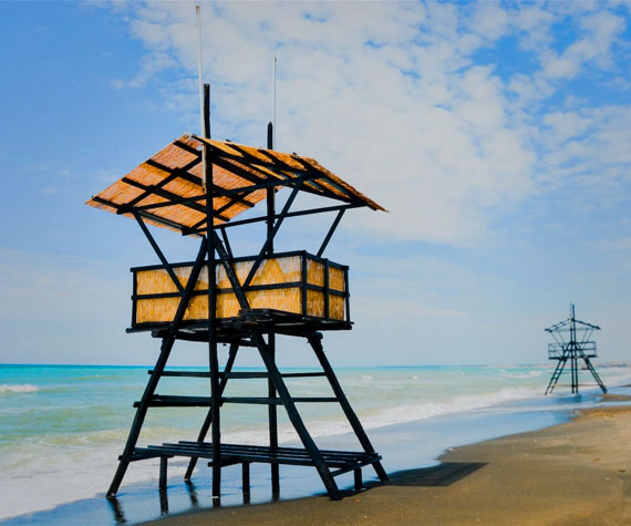 Two empty lifeguard towers on the beach as the tide rolls in